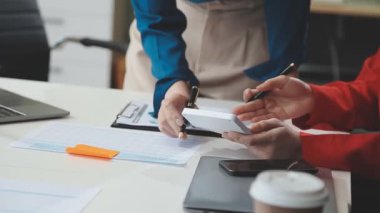 Modern bir ofiste çalışan profesyonel kadınlardan oluşan bir ekip mali belgeleri inceliyor..