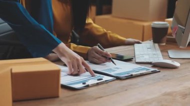 Depoda karton kutularla finansal belgeleri inceleyen bir grup profesyonel kadın, online alışveriş kavramı 