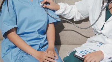 Steteskop ve hastane personeli olan doktor ve kadın hasta.