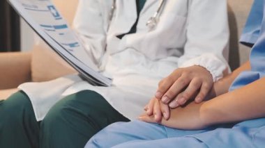 Doktor hastanın elini tutuyor.