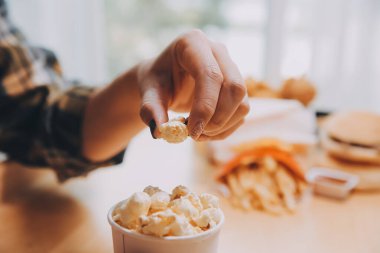 Elinde patlamış mısır kasesi tutan bir kadın.