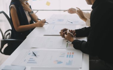 Finansal analistler, şirketlerin başarılı takım çalışmalarının sonuçlarını gösteren bir toplantıda bir dijital tablet planlama yatırım projesinin ticari mali raporlarını analiz ediyorlar..