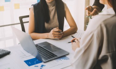 Finansal analistler, şirketlerin başarılı takım çalışmalarının sonuçlarını gösteren bir toplantıda bir dijital tablet planlama yatırım projesinin ticari mali raporlarını analiz ediyorlar..