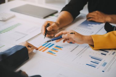 Finansal analistler, şirketlerin başarılı takım çalışmalarının sonuçlarını gösteren bir toplantıda bir dijital tablet planlama yatırım projesinin ticari mali raporlarını analiz ediyorlar..