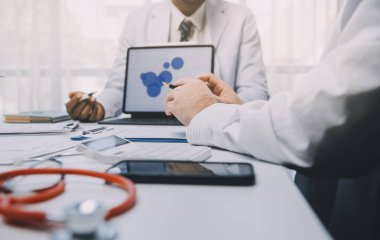 Görüşme, tablet ve doktorlardan oluşan bir ekip sağlık hizmetlerinden ve tele-sağlık uygulamalarından konuşmak için ofiste. Hastane finansmanı veya sponsorluğu için internet sitesiyle cerrah grubu, teknik ve tıbbi tartışmalar