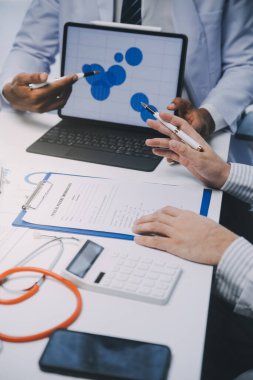 Görüşme, tablet ve doktorlardan oluşan bir ekip sağlık hizmetlerinden ve tele-sağlık uygulamalarından konuşmak için ofiste. Hastane finansmanı veya sponsorluğu için internet sitesiyle cerrah grubu, teknik ve tıbbi tartışmalar