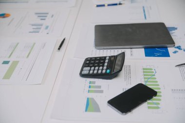 Finansal analistler, şirketlerin başarılı takım çalışmalarının sonuçlarını gösteren bir toplantıda bir dijital tablet planlama yatırım projesinin ticari mali raporlarını analiz ediyorlar..