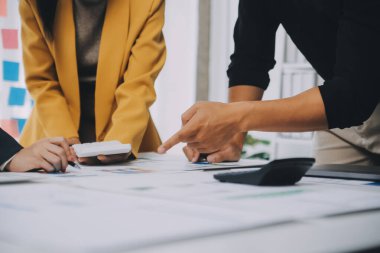 Finansal analistler, şirketlerin başarılı takım çalışmalarının sonuçlarını gösteren bir toplantıda bir dijital tablet planlama yatırım projesinin ticari mali raporlarını analiz ediyorlar..