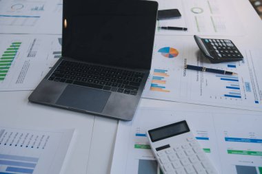 Finansal analistler, şirketlerin başarılı takım çalışmalarının sonuçlarını gösteren bir toplantıda bir dijital tablet planlama yatırım projesinin ticari mali raporlarını analiz ediyorlar..