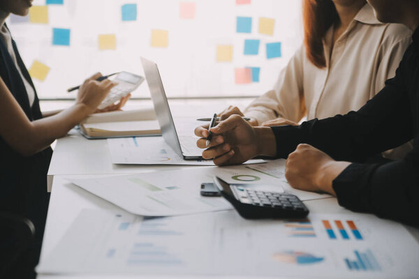 Финансовые аналитики анализируют деловые финансовые отчеты по инвестиционному проекту цифрового планшетного планирования в ходе обсуждения на совещании корпораций, показывающего результаты их успешной командной работы.