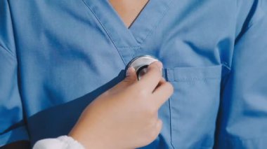 Elinde steteskop tutan mavi ceketli bir doktor..