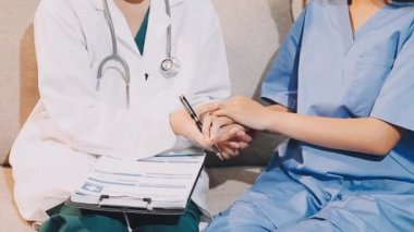 Genç bayan doktor hastanın koluyla konuşuyor.