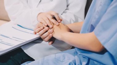 Beyaz üniformalı doktor hastanedeki bir hastaya reçete yazıyor..