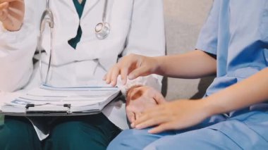 Doktor hastanın elini tutuyor.