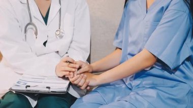 Kadın doktor hastane koğuşunda hasta tutuyor.