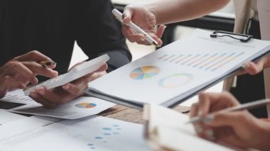 Bir grup iş adamı birlikte beyin fırtınası yapıyor ve ofiste fikirleri tartışıyor. Takım çalışması ve ortaklık kavramı