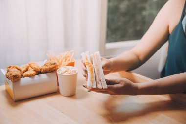 Asyalı sağlıklı bir kadın sabah sandviçle kahvaltı yapar.