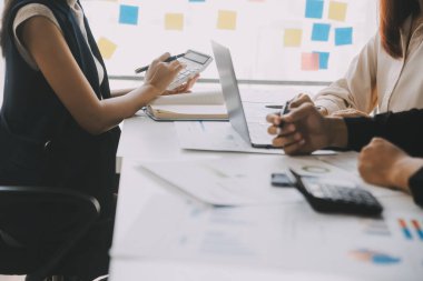 Finansal analistler, şirketlerin başarılı takım çalışmalarının sonuçlarını gösteren bir toplantıda bir dijital tablet planlama yatırım projesinin ticari mali raporlarını analiz ediyorlar..