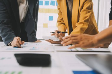 Finansal analistler, şirketlerin başarılı takım çalışmalarının sonuçlarını gösteren bir toplantıda bir dijital tablet planlama yatırım projesinin ticari mali raporlarını analiz ediyorlar..