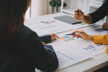 Finansal analistler, şirketlerin başarılı takım çalışmalarının sonuçlarını gösteren bir toplantıda bir dijital tablet planlama yatırım projesinin ticari mali raporlarını analiz ediyorlar..