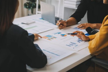 Finansal analistler, şirketlerin başarılı takım çalışmalarının sonuçlarını gösteren bir toplantıda bir dijital tablet planlama yatırım projesinin ticari mali raporlarını analiz ediyorlar..