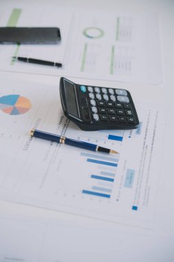 Finansal analistler, şirketlerin başarılı takım çalışmalarının sonuçlarını gösteren bir toplantıda bir dijital tablet planlama yatırım projesinin ticari mali raporlarını analiz ediyorlar..