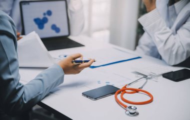 Görüşme, tablet ve doktorlardan oluşan bir ekip sağlık hizmetlerinden ve tele-sağlık uygulamalarından konuşmak için ofiste. Hastane finansmanı veya sponsorluğu için internet sitesiyle cerrah grubu, teknik ve tıbbi tartışmalar