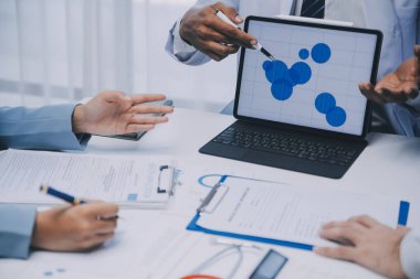 Görüşme, tablet ve doktorlardan oluşan bir ekip sağlık hizmetlerinden ve tele-sağlık uygulamalarından konuşmak için ofiste. Hastane finansmanı veya sponsorluğu için internet sitesiyle cerrah grubu, teknik ve tıbbi tartışmalar