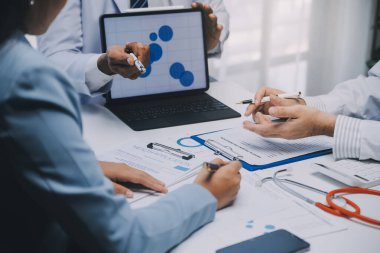 Görüşme, tablet ve doktorlardan oluşan bir ekip sağlık hizmetlerinden ve tele-sağlık uygulamalarından konuşmak için ofiste. Hastane finansmanı veya sponsorluğu için internet sitesiyle cerrah grubu, teknik ve tıbbi tartışmalar