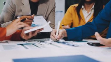 Modern ofiste dizüstü bilgisayar ve mali raporlarla çalışan genç iş adamları