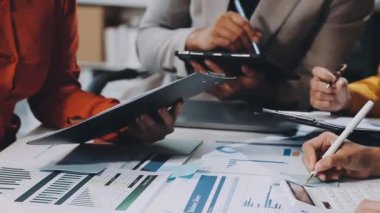 Genç iş adamları ofiste mali belgeleri tartışıyor