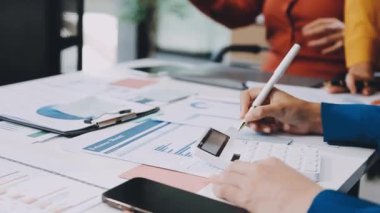 İş adamları masadaki çizelge ve grafikleri tartışıyor