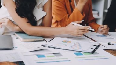 Bir grup iş adamı ofisteki bir masada proje tartışıyor ve planlıyor.