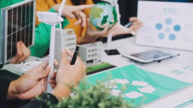 Genç iş adamı elinde güneş enerjisi panelleri tutuyor.