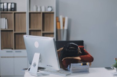 İş kadını ve çalışan ofis masasında çalışırken biraz kestiriyorlar. Çalışan kadınlar yorgun ve masada uyuyorlar.