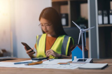 Evde çalışan kadın mimar planlara baktı..