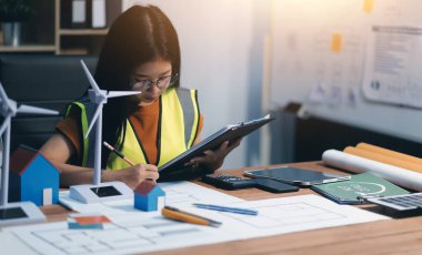 Evde çalışan kadın mimar planlara baktı..