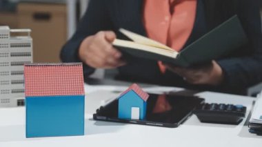 Ev modeli ve emlak konseptini elinde tutan bir işadamı