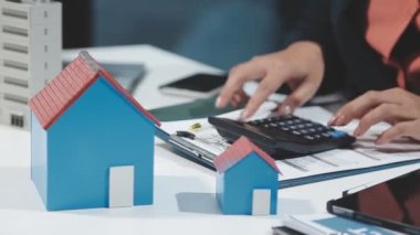 Emlakçı evin anahtarını tutuyor ve tablet kullanıyor..