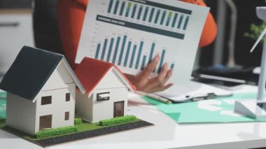 Yeşil ev modeli ve emlakçı tutan bir iş adamı. Emlakçı