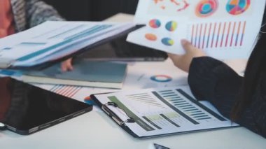 İş kadınının laptopunu kullanarak ve ofisteki çizelgeye yazarak fotoğrafını çek..