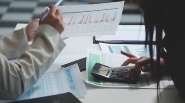 İş yerinde hesap makinesi ve kalemi olan bir iş kadını