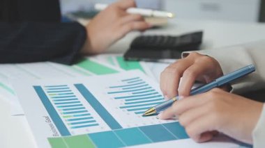 Bir bilgisayarda grafikleri ve grafikleri analiz eden iş adamları