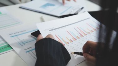 İşadamları hesap makinesiyle finansal tabloları analiz ediyorlar..