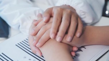 Kapat. Kadın elleri hastasını tutuyor..