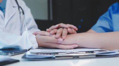 Doktorlar ellerinde steteskop ve beyaz arka planda hasta tutuyorlar.