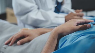 Doktor hastanın elini tutuyor.