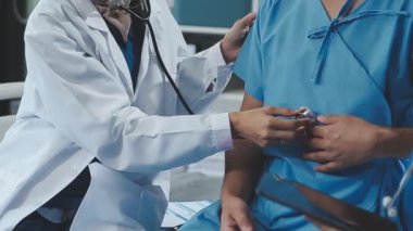 Üniformalı doktor hasta muayene ediyor.