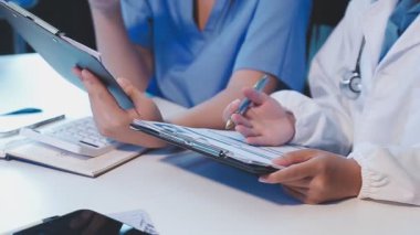 Doktor elinde tablet bilgisayar ve tıbbi kayıtları olan hasta tutuyor.