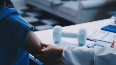 Doktor üniformalı, hastayı muayene ediyor.